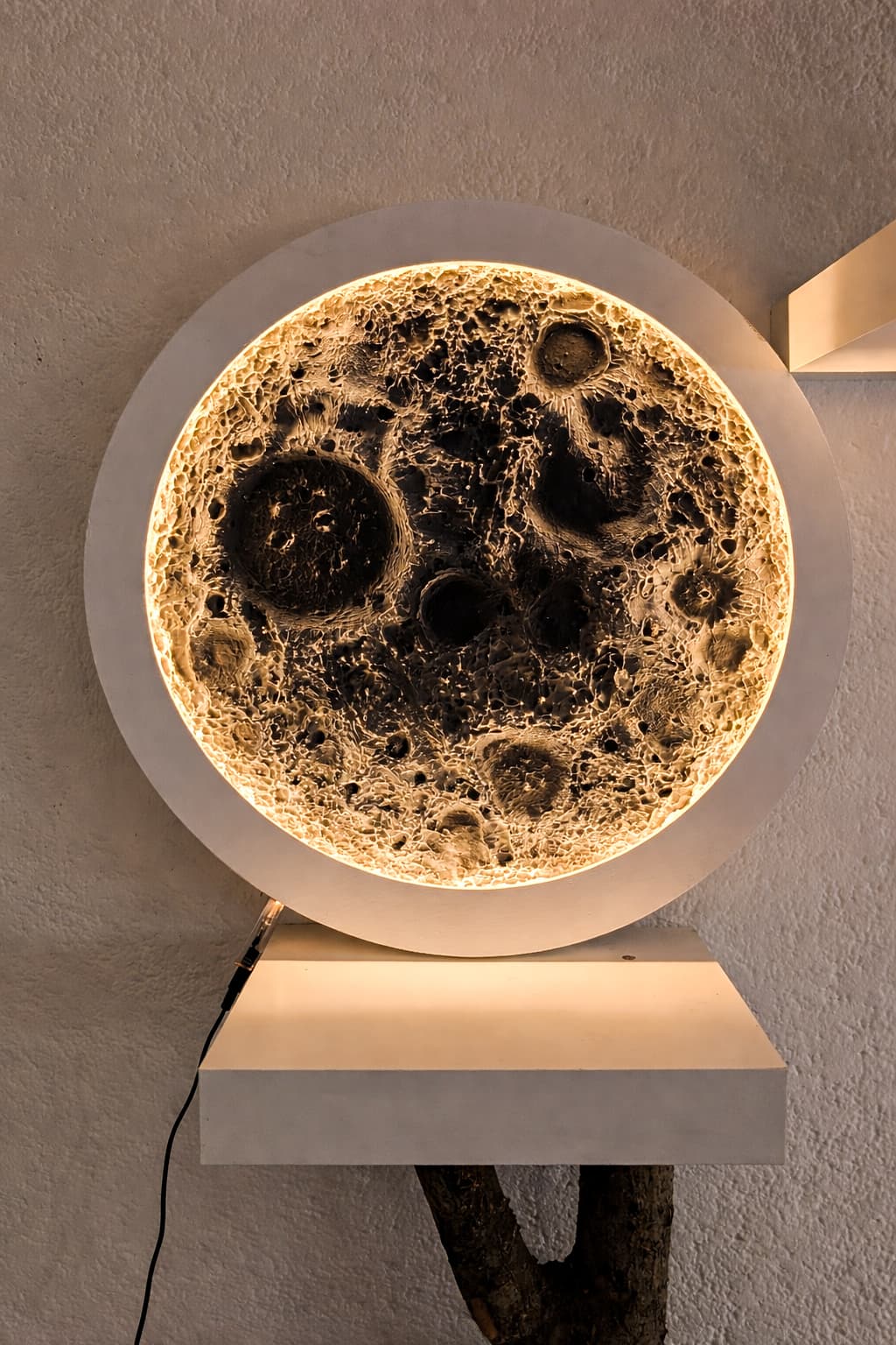 Hinterleuchtete Wandleuchte mit detailreicher Mondoberfläche und Kratern, die ein warmes, goldenes Licht ausstrahlt.